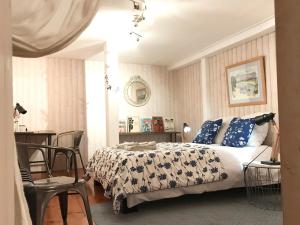 AzasVilla Toscane - Atelier d'Artistes et B&B à 20 mn de Toulouse的一间卧室配有一张带蓝白色床单的床和一张桌子