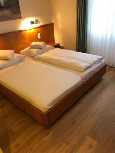 伯根Seminar- und Urlaubshotel Schulz的卧室内的一张大床,铺有木地板