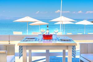 斯卡拉拉扎海滩酒店的一张桌子,上面有一瓶葡萄酒和眼镜,放在沙滩上