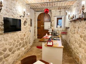 坎波迪焦韦B&B Casa Antonetti的一间带石墙的厨房和一台墙上的电视