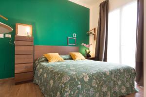 马尔萨拉Il Sogno Apartments的绿色卧室,配有床和绿色的墙壁
