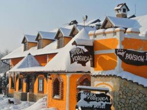 Klanjec斯塔拉沃德尼采住宿加早餐旅馆的一座橙色的建筑,上面有雪