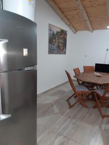 圣拉斐尔El Nevado Casa de Campo的厨房配有桌子和不锈钢冰箱。
