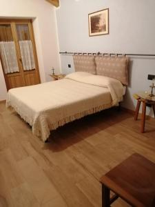 RiclarettoLa scuola的一间卧室设有一张大床,铺有木地板