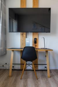 努克HOTEL SØMA Nuuk的桌椅和平面电视