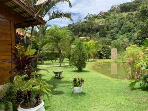 弗洛里亚努元帅镇Chácara em Marechal Floriano的院子里种有植物和长凳的花园