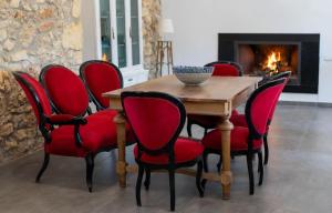 哈恩Alojamiento rural La Granja de Las Monjas的一间带木桌和红色椅子的用餐室