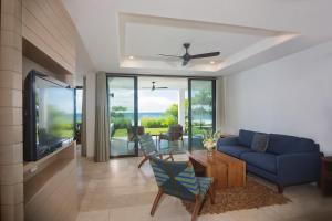 IguanaIguana Beach House的客厅配有蓝色的沙发和电视
