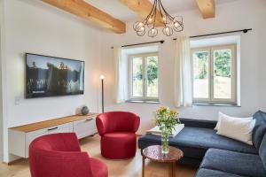 OrtSeechalet Traunsee的客厅配有蓝色的沙发和红色的椅子