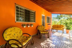 三玛丽亚镇Pousada e Restaurante Maria das Flores的一间设有两把椅子和橙色墙壁的房间