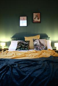 科尔切斯特The Velveteen Townhouse的卧室内的一张床位,卧室拥有绿色的墙壁和枕头