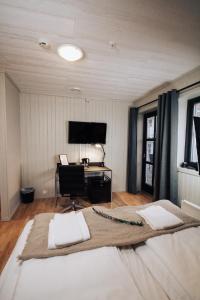 勒丁恩Lødingen Brygge的一间卧室配有一张带书桌和钢琴的床。