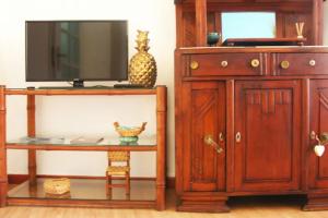 里斯本The Spot in Alfama的配有电视、橱柜和桌子的房间