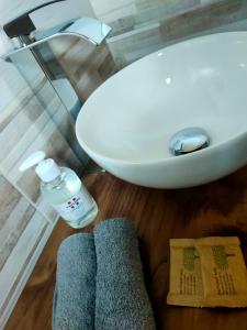 奥斯塔Locanda mami的浴室配有水槽、一瓶水和毛巾