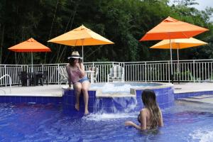 拉维加Ecohotel Monteverde的两个女人坐在游泳池里