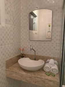 安格拉杜斯雷斯Sua casa的浴室配有盥洗盆、镜子和毛巾