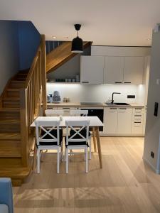 哈普萨卢Vanalinna apartment的一间带桌椅和楼梯的厨房