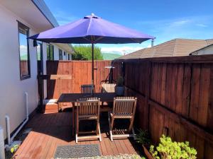陶波Almost Country的一个带桌子和紫色雨伞的庭院