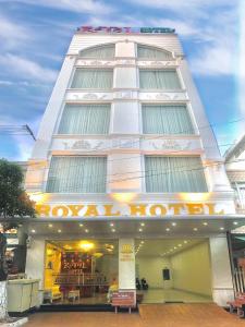 Bạc LiêuRoyal Hotel的一座高大的白色建筑,上面有标志