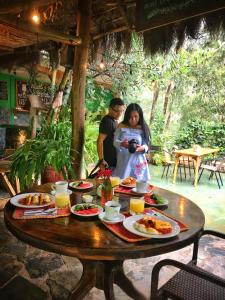 圣特雷莎盖丘亚生态山林小屋的男人和女人站在餐桌旁吃饭