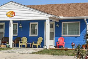 大西洋滩Toes In The Sand的蓝色的房子,前面有五颜六色的椅子
