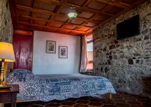San Antonio Palopó特拉萨斯拉戈酒店的一间卧室设有一张床和石墙