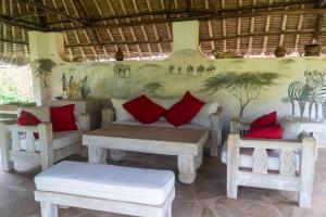 迪亚尼海滩Amani Paradise - Luxury Villas的一间配有沙发和两张桌子及椅子的房间