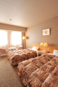 诹访市RAKO华乃井宾馆的酒店客房设有两张床和窗户。