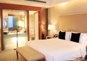 哈尔滨哈尔滨索菲特大酒店的卧室配有一张白色大床和一把椅子