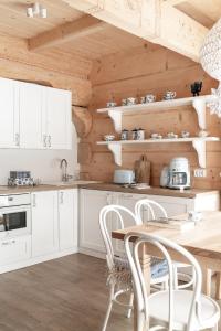 考斯赛力克Śnieżna Dolina - Sobiczkowa Bór Luxury Chalets的厨房配有白色橱柜和木墙
