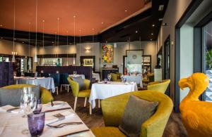 埃比尼轩尼诗百乐酒店的餐厅设有白色的桌子和黄色的椅子