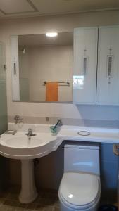 西归浦市城山友利大厦度假屋的一间带水槽、卫生间和镜子的浴室