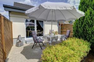 弗伦斯堡Ferienwohnung Aneta的露台配有桌椅和遮阳伞