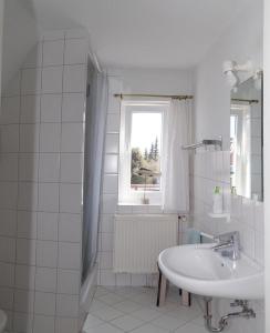 哈里斯莱Feddersen's Ferienwohnung的白色的浴室设有水槽和窗户。