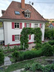 NiedereschachB&B Rosenliebe的白色的房子,有红色百叶窗和花园