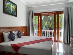 美奈Four Oceans Beach Resort - Bon Bien Mui Ne的一间卧室设有一张床和一个大窗户
