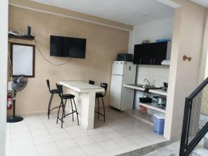 坎昆Casa de Ana - Habitación privada的厨房配有桌椅和冰箱。