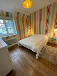 滨海吕克Balaena - maison avec jardin proche plage的一间卧室设有一张床和色彩缤纷的墙壁