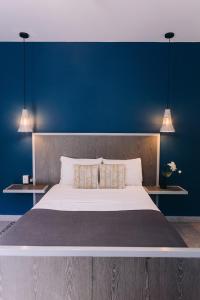 克雷塔罗Septimo Hostal的一间卧室设有一张蓝色墙壁的大床