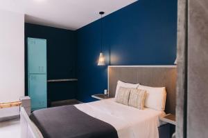 克雷塔罗Septimo Hostal的一间卧室设有一张床和蓝色的墙壁