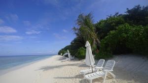 乌库拉斯Coco Villa Ukulhas的海滩上设有椅子和遮阳伞,大海
