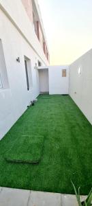 迪拜HAVANA HOLIDAY HOMES MIRDIF的建筑里一个绿草成荫的空房间