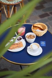 巴黎Hôtel du Sentier的一张带食物盘子和一篮面包的蓝色桌子