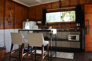 新彼得罗波利斯Rancho VSS Cabana da Montanha 1的厨房配有桌椅和炉灶。
