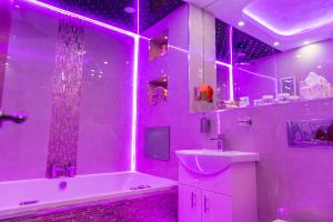布雷得佛Meridian Serviced Apartments的紫色浴室设有浴缸、水槽和浴缸