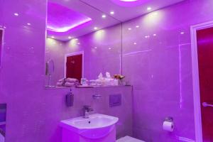 布雷得佛Meridian Serviced Apartments的紫色浴室设有水槽和镜子