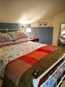 BallyclareRiverside Cottage at Logwood Mill的一间卧室配有一张带花被的床