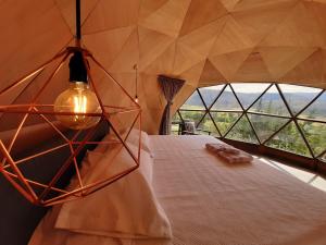 伊萨Glamping NIDO VERDE的一间卧室设有一张大床和大窗户