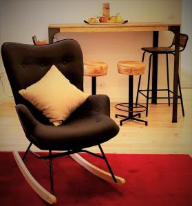 毕尔巴鄂Apto IBAIONDO-Con encanto, céntrico y comunicado的客厅配有带枕头的黑色摇椅