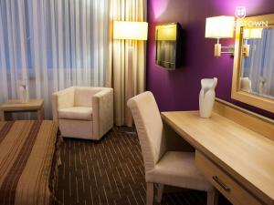 绿山城Grape Town Hotel - Park79的酒店客房配有一张床、一张桌子和一把椅子。